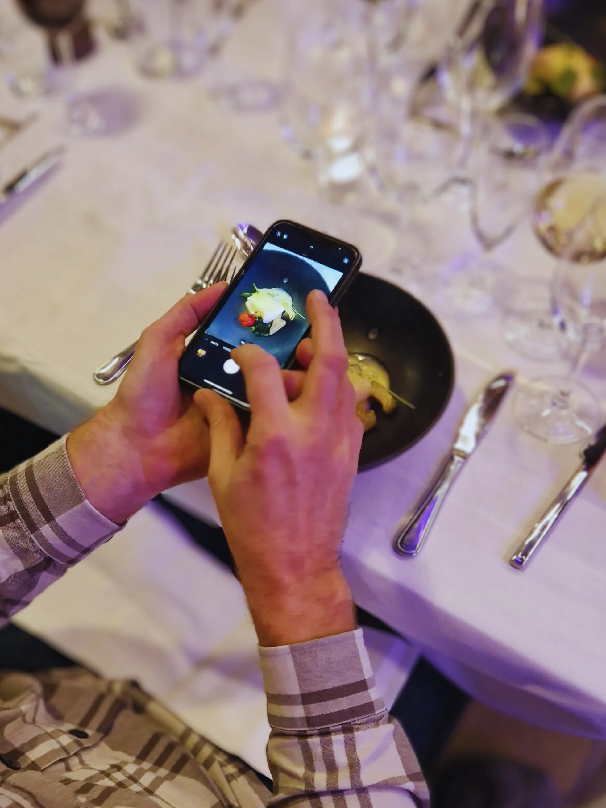 Gjest som fotograferer et middagskurs på et Kanon-arrangement
